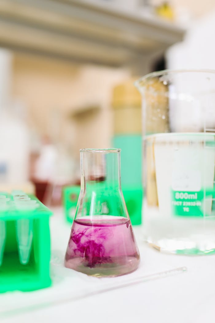 Chemistry lab with flask and beaker containing colorful solutions for experimental research.